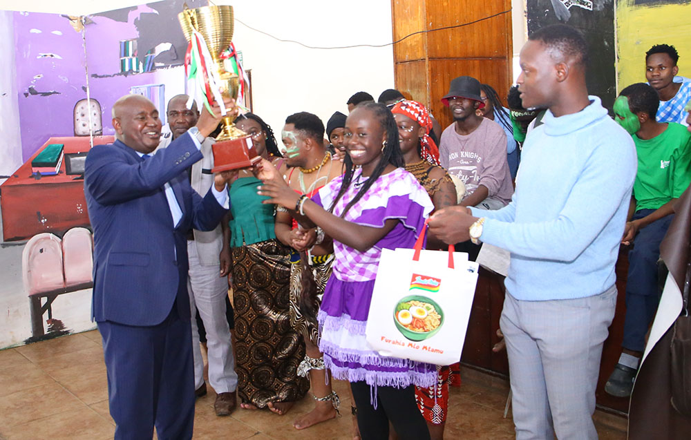 VC Prof. Benedict Mutua (left) receives one of the trophies TU-K won during the KUPAA National Drama Festivals