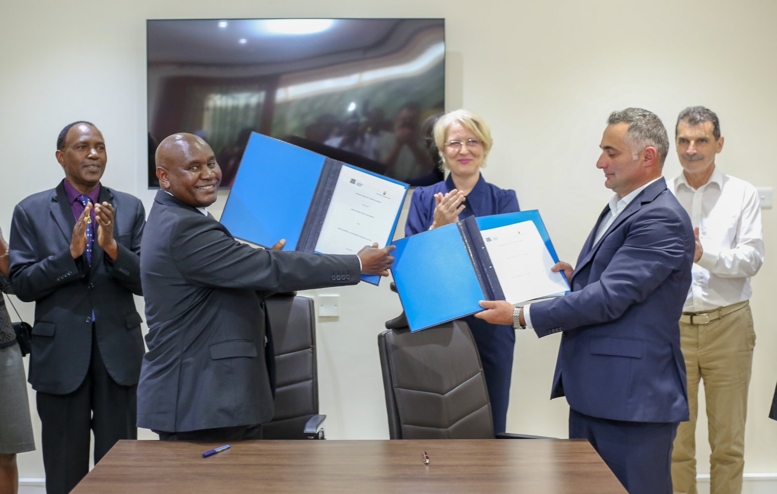 VC, Prof. Benedict Mutua (2nd L) and Transilvania University of Brașov Dean, Faculty of Furniture Design and Wood Engineering, Prof. Alin OLĂRESCU (2nd R) presents the signed MoU. Present during the occasion was DVC -IAE Prof. Paul Wambua (L) and Romanian Ambassador to Kenya, H.E Gentiana Serbu (3rd R) among other guests.