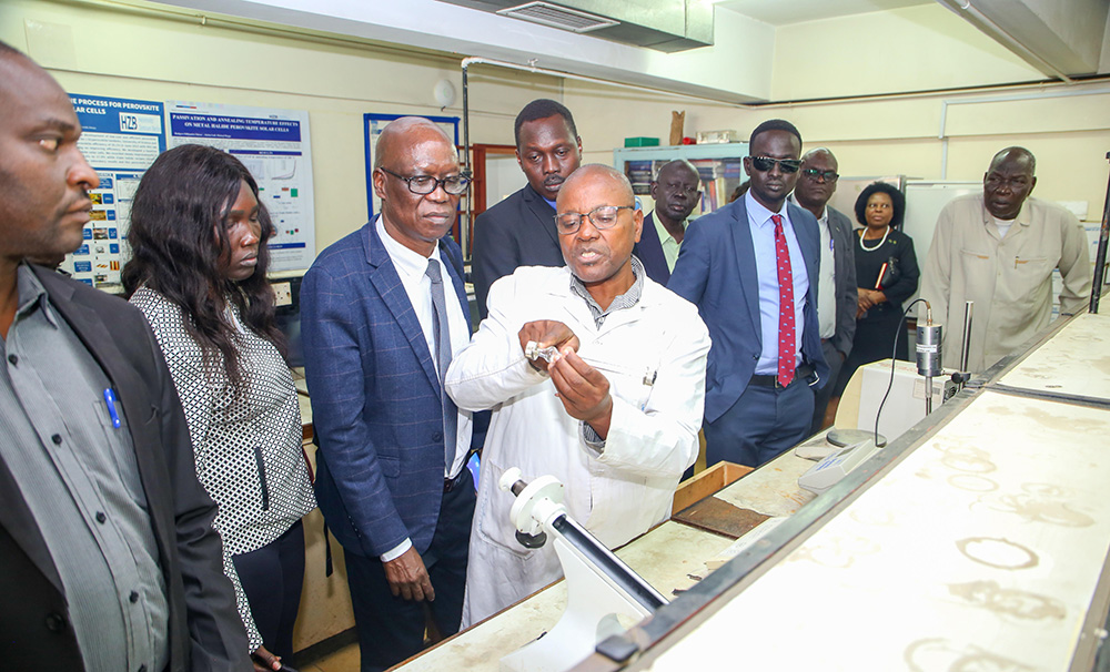 Samson Kidiga, a Senior Technologist at the Department of Chemistry and Materials Sciences taking visiting guests from the University of Juba through technical aspects of the laboratory equipment